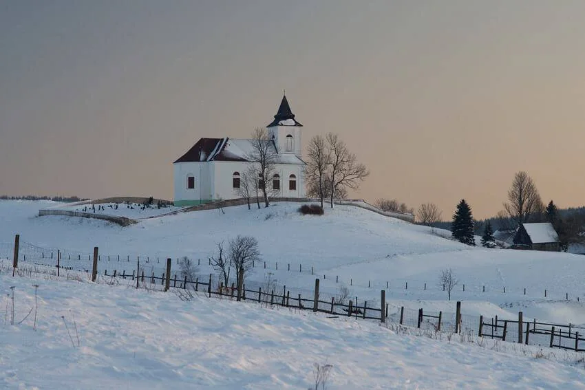 Zasněžený kostel svatého Václava na kopci nad Kalkem v zimě