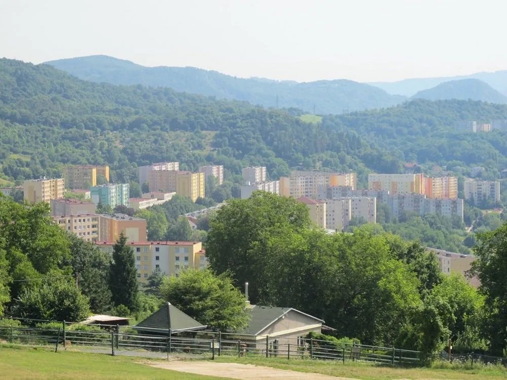 Výhled ze Zoo Ústí nad Labem přes výběh na paneláky a zalesněné kopce