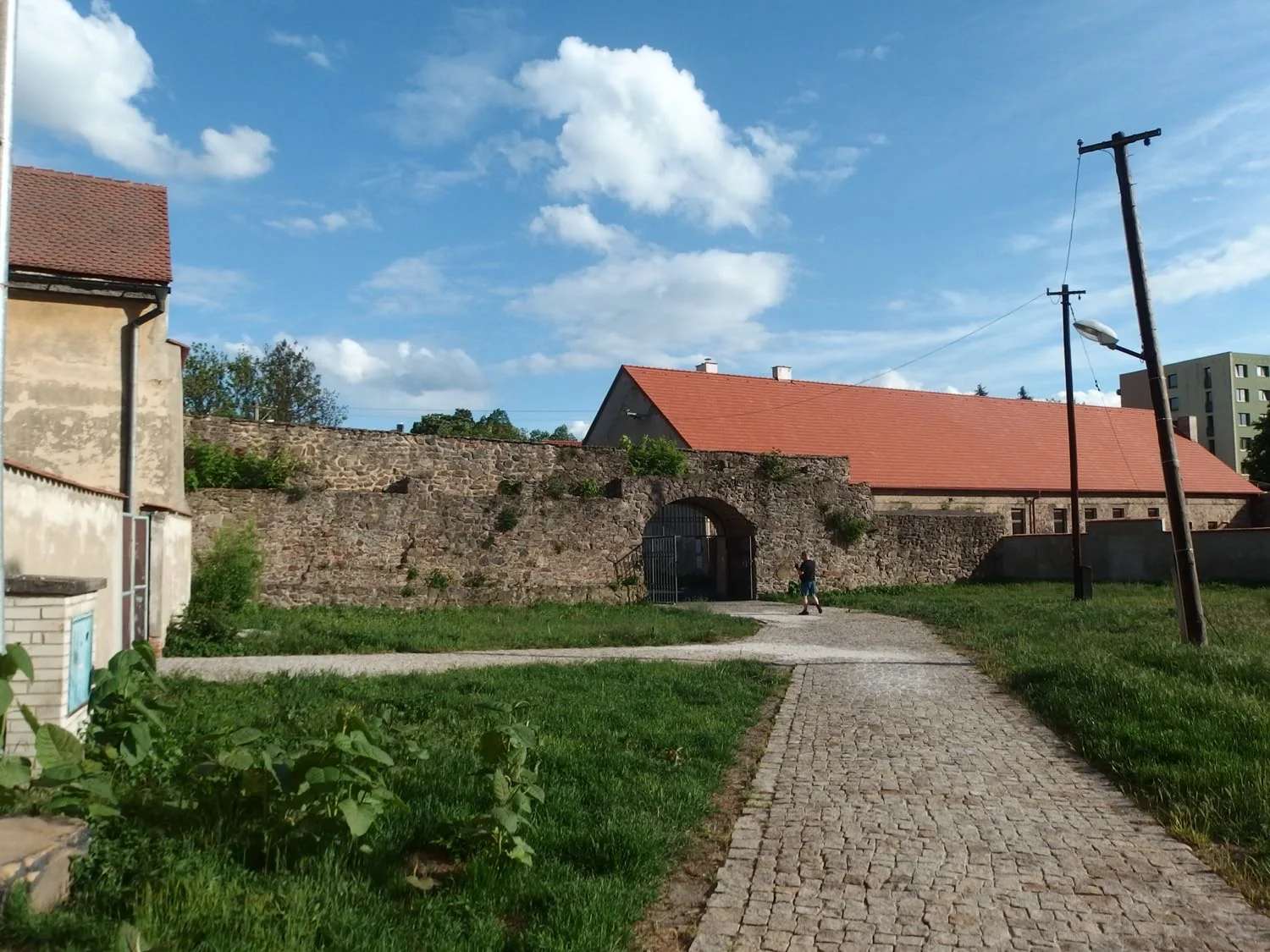 Zbytek městské hradby u fary v Bílině s klenutým průchodem