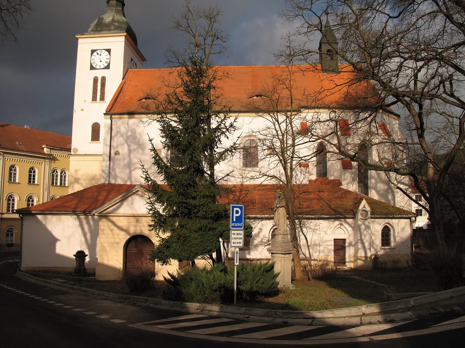 Kostel svatého Petra a Pavla na Mírovém náměstí v Bílině, holé stromy