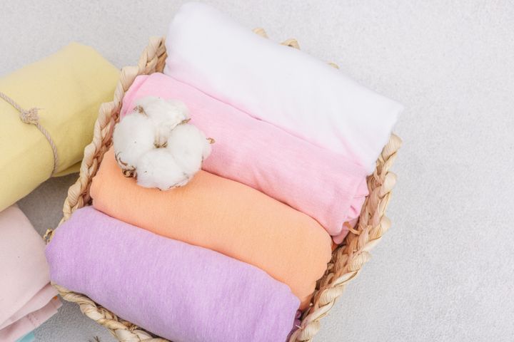 prostěradlo Bavlněné látky v košíku. Pastelové barvy, měkké materiály. Ideální pro šití dětského oblečení a povlečení.