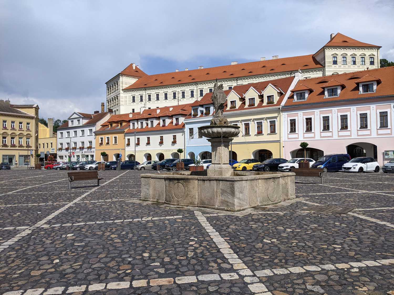Floriansbrunnen am Mírové náměstí in Bílina mit dem Schloss im Hintergrund