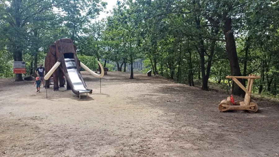 Skluzavka zabudovaná do dřevěného mamuta na hřišti v Pohádkovém lese