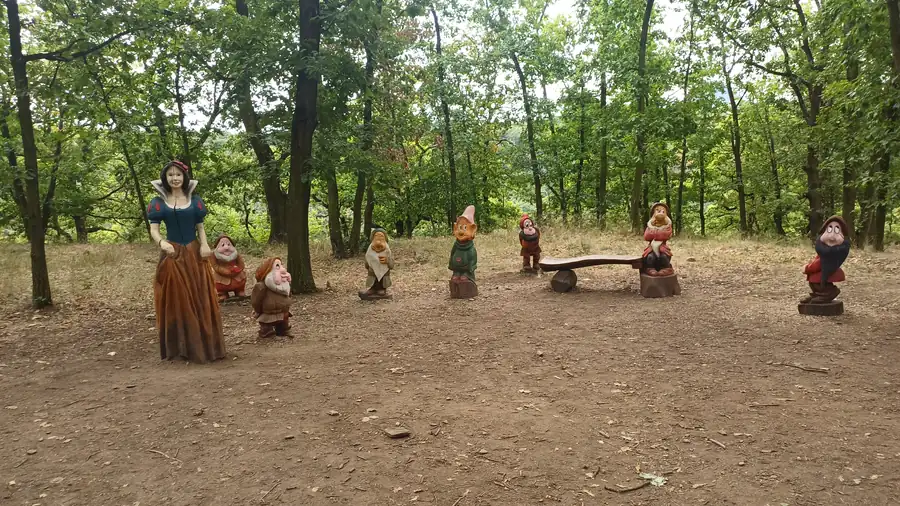 Sněhurka a sedm trpaslíků vyřezaní ze dřeva v Pohádkovém lese v Bílině