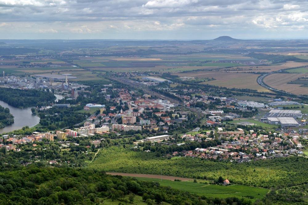 Pohled z vrcholu Lovoše na Lovosice sevřené mezi Labe, chemičku a dálnici D8
